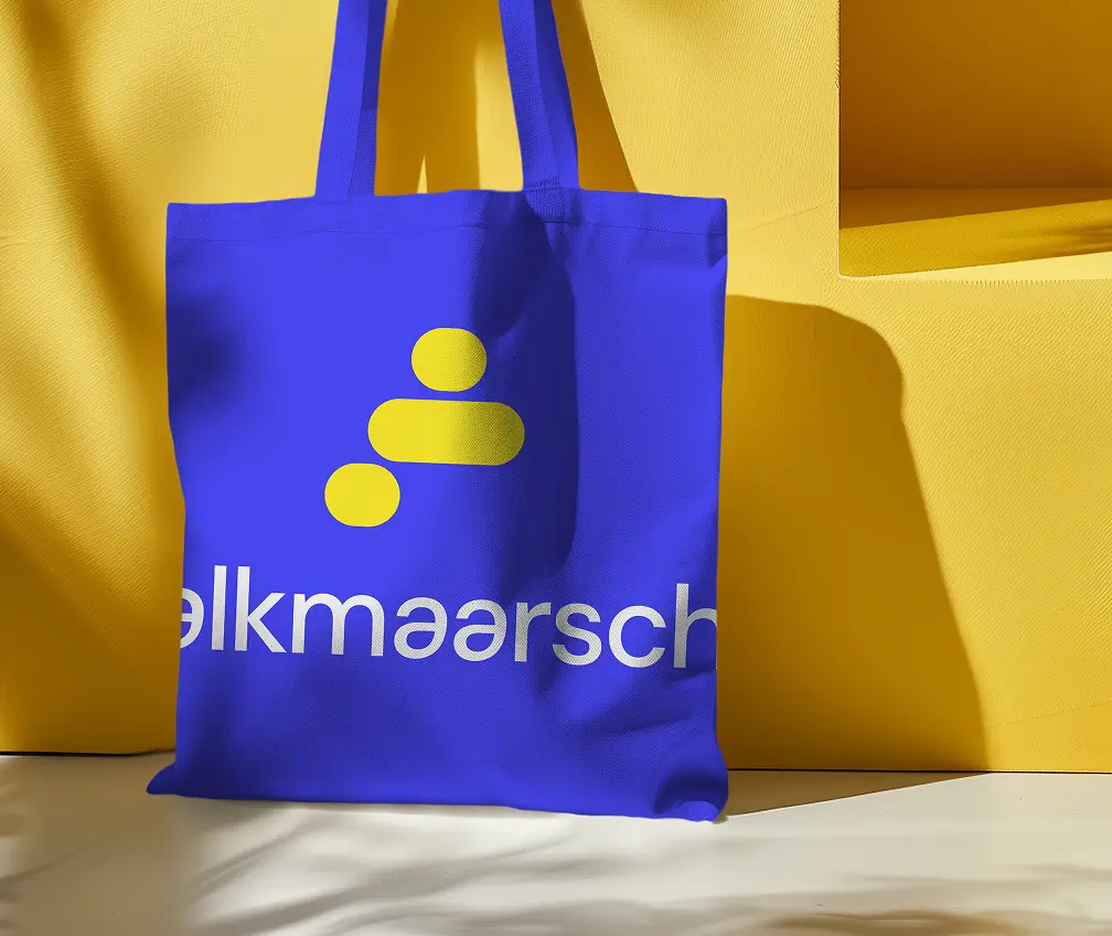 Een foto van een katoenen tas met daarop het logo van Alkmaarsch. Het vertelt een stukje over Alkmaarsch.