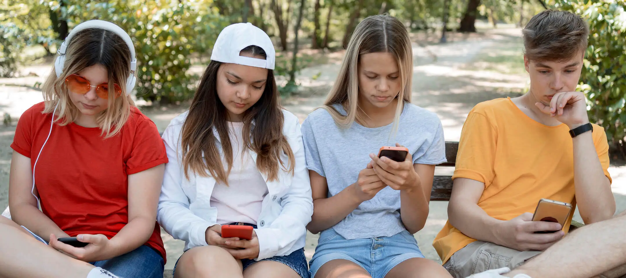 Een foto van Generatie Z en Alpha, zittend op een bankje met hun mobiele telefoon in de hand om een website en/of webshop te bezoeken.